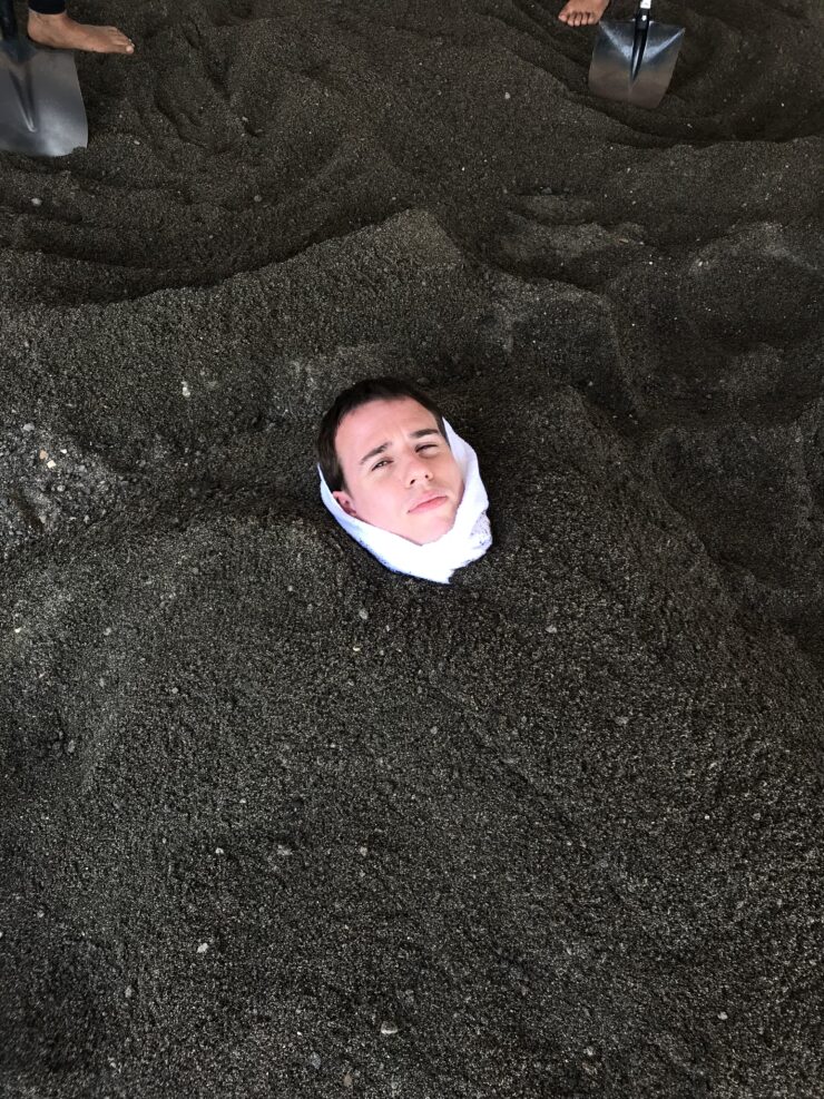 Homme enterré dans le sable noir fumant à Ibusuki au Japon