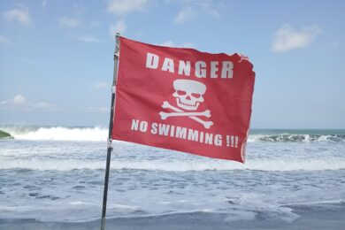 Drapeau de danger sur une plage de Bali - Conseils de sécurité pour les retraits d'argent et éviter le skimming.