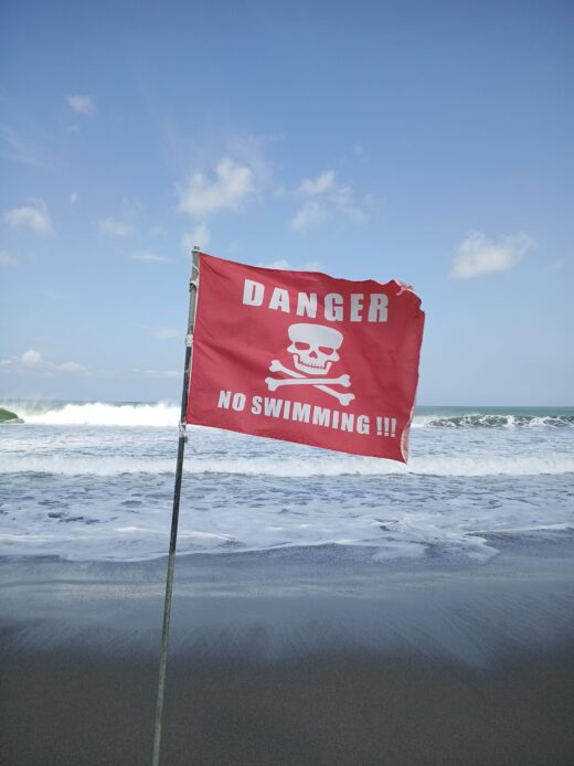 Drapeau de danger sur une plage de Bali - Conseils de sécurité pour les retraits d'argent et éviter le skimming.