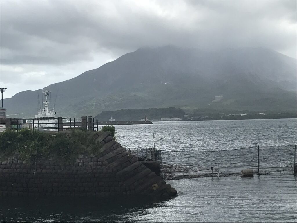 Vue du volcan Sakurajima sous un ciel gris depuis le port de Kagoshima