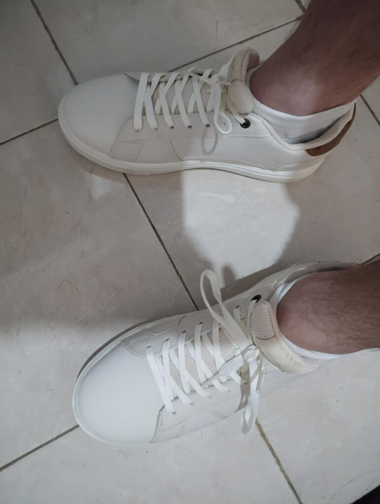 Paire de baskets blanches Aerostreet portées à Bali, alternative stylée et locale aux tongs habituelles.