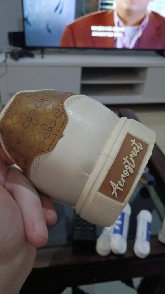 Gros plan sur le logo Aerostreet et le motif batik doré à l'arrière de la chaussure avant personnalisation.