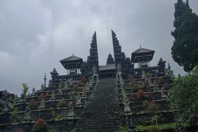 Des visiteurs gravissent les grands escaliers en pierre menant aux portes intérieures du complexe de temples hindous de Pura Besakih à Bali.